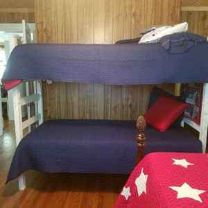 Patriotic Room with a full size bed, bunk twin beds, table and chairs and a baby crib.