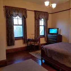 Mahogany Room with desk and flat screen Dish TV.